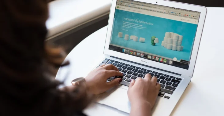 Pessoa usando um notebook com site aberto e conteúdo na tela, sugerindo como um site pode se tornar o principal canal de contato com clientes.